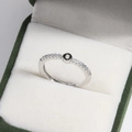Detail of silver paved ring with black circular motif in green velvet jewelry box - Platinum O