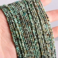 Macro shot of natural green turquoise round beads with brown textures on a hand - African Pine Stone