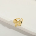 Makroaufnahme eines goldenen Schleifenrings mit strukturierter Oberfläche auf Weiß - Schleife (Gold)