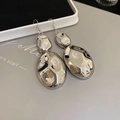 Detailed close-up of glossy silver-finish pleated metal earrings with reflective mirror effect - Hook Earrings / Silver