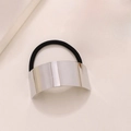 Minimalistisches elastisches Haargummi mit poliertem Silbermetallteil auf beigem Grund - Gebogene Spiegeloberfläche / Silber