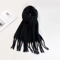 Close-up of black mohair scarf showing soft fuzzy texture and long tassel fringe details - Black