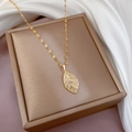 Elegant gold necklace with sparkling diamond clover pendant on silk background - Leaf Necklace (Lip Chain) / Gold