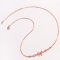 Detalle del collar con colgante de lazo en oro rosa con circonitas rosas y violetas - Oro rosa
