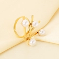 Detailansicht eines goldenen Edelstahlrings mit vier weißen Perlen auf Champagner-Satin - Vier-Perlen Geometrischer Stil(KR113363-SP)