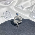 Macro shot of silver snake ring with blue pear gemstone and crystals on dark stone - Style 7 Adjustable Ring