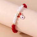 Close-up of a Christmas beaded bracelet featuring a red reindeer charm and white pearls - Red/White Beads-Reindeer Charm