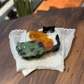 Detailansicht von drei Katzen-Haarklammern aus Acetat auf weißer Spitze und Holz - Spähende drei kleine Kätzchen