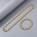 Dettaglio di un set di gioielli in acciaio al titanio dorato con collana e bracciale - Collana / Oro