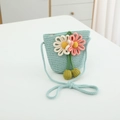 Détail d'un sac bandoulière en paille tressée avec fleurs au crochet et pompons verts - Sac / Bleu lac
