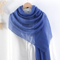 Detail of a light blue pleated cotton linen scarf draped over a wooden hanger - Blue