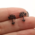 Detailed close-up of black tree branch stud earrings held by hand for size comparison - Black
