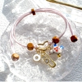 Pink hand-woven cord bracelet with ceramic bird and gold heart charm on glass tray - Pink Woven Rope Ceramic Bird Wood Beads Charm Bracelet