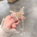 Detailed view of a golden butterfly hair claw with pearls and hanging tassel pendants - Gold Full Pearl Butterfly