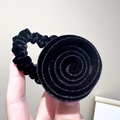Détail macro d'une pince à cheveux rose en velours noir avec texture scintillante - Chouchou Fleur Rose en Velours Noir