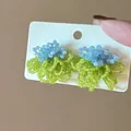 Detailed view of handmade beaded floral earrings in sky blue and green on a white display card - 11# Blue & Green Beaded Flower Cluster (925 Sterling Silver Earring Post)