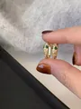 Detailed macro view of gold-plated snake head hoop earrings with shimmering white cubic zirconia - Gold Style (Silver Post)