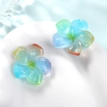 Gros plan de fleurs frangipanier en résine sur plat blanc avec reflets d'eau - Cyan