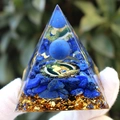 Blue crystal pyramid with Buddha emblem and gold flakes held in a white gloved hand - Lapis Lazuli Buddha / Small