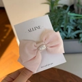 Detail of pink cotton linen bow hair clip with oval metal buckle on brand card - Creamy Pink Bowknot Duckbill Clip