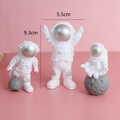 Three astronaut cake toppers with silver visors and height measurements on pink background - Plastic Astronaut Silver
