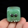Handheld view of a green aventurine square stone ornament with a cute smiling face - Green Aventurine