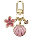 Goldener Schlüsselanhänger mit rosa Blumen, Muscheln und Strasssteinen auf weißem Grund - Rosa Ozean Muschel Lila Diamant Blume