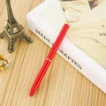 Penna a sfera rossa metallizzata con un grande cristallo a cuore su un libro bianco - Rosso