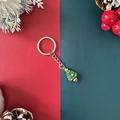 Christmas tree keychain with green pendant and silver ring on a festive background - Christmas Tree Style 2