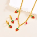 Detailed shot of golden necklace and strawberry earrings on white stone props - Necklace + Earrings