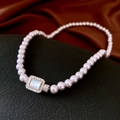 Detailed shot of vintage pearl necklace with a zircon-encrusted rectangular pendant - Emerald Cut Gem Pendant / Pink