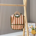 Waterproof baby bib with orange and white vertical stripes and green trim detail - Nordic Style