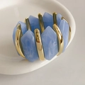 Détail de résine marbrée bleue et barres en métal doré sur un bracelet élastique - Bleu