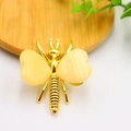 Golden honeybee craft with heart-shaped yellow crystal stone wings on wood background - Gold Plated Topaz Stone