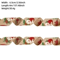 Detail view of 6.5cm linen Christmas ribbon with Santa Gnome and holly leaf prints - Khaki Gnome / 4 Meters