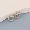 Detail of silver oval hoop earrings with snake scale texture on white stone base - Silver Scale Texture C-Shape