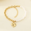 Detailed view of gold chain link bracelet with white pearl and hollow heart pendant - Hollow Carved Heart (KB203710-Z)