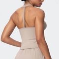Detail of beige yoga set featuring a cross-back sports bra and high-waist shorts - Flaxen