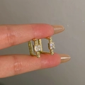 Vintage style square gold stud earrings with clear rhinestones held to show scale - Square Rhinestone Gold