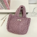 Detail of soft purple plush sherpa tote bag with a minimalist logo tag and carry handle - Light Purple