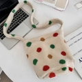 Close-up of cream faux shearling bucket bag with colorful polka dots on a white desk - Colorful Polka Dots