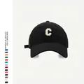 Detail of white 3D embroidered C letter on black cotton baseball cap with fabric texture - Adjustable / Black