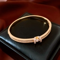 Detalle de cerca del brazalete ovalado chapado en oro de 18K con microcristales pavimentados - Dorado