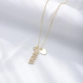 Dettaglio della collana dorata MAMA con zircone e cuore su seta bianca lucida - Argento 925 / Oro
