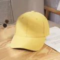 Top view of a yellow twill cotton baseball cap on a rustic wood surface with dried flowers - Yellow