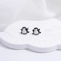 Close-up of cute S925 silver penguin stud earrings with black and white enamel finish - Penguin