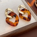 Nahaufnahme der geometrischen Ohrringe mit Goldring und Schildpatt-Harz-Anhänger - Stil 5 (Gold-Braun Raute)