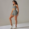 Detail view of seamless high-waist yoga shorts and racerback bra in sage green - Dark Gray