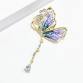 Détail d'une broche papillon vintage avec ailes dégradées et cristaux pendants - Violet