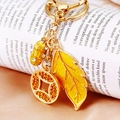 Golden keychain with yellow crystal feather, car, and coin charms for car keys - Golden Feather & Car